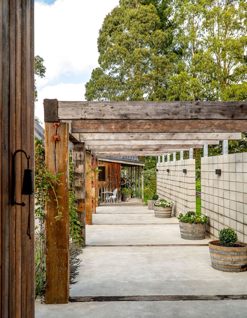 The solid timber pergola connects the house and barn.