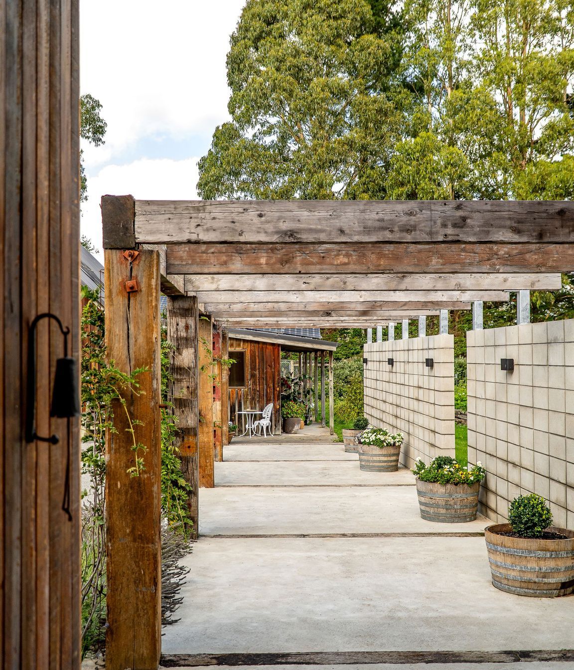 The solid timber pergola connects the house and barn.
