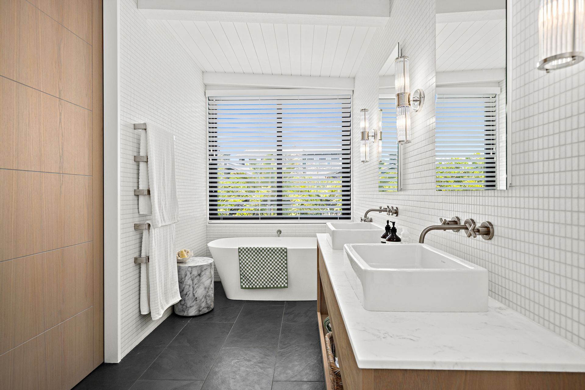 A Carrara marble benchtop pairs with white Vixel glass mosaic tiles from Artedomus in the main bathroom.