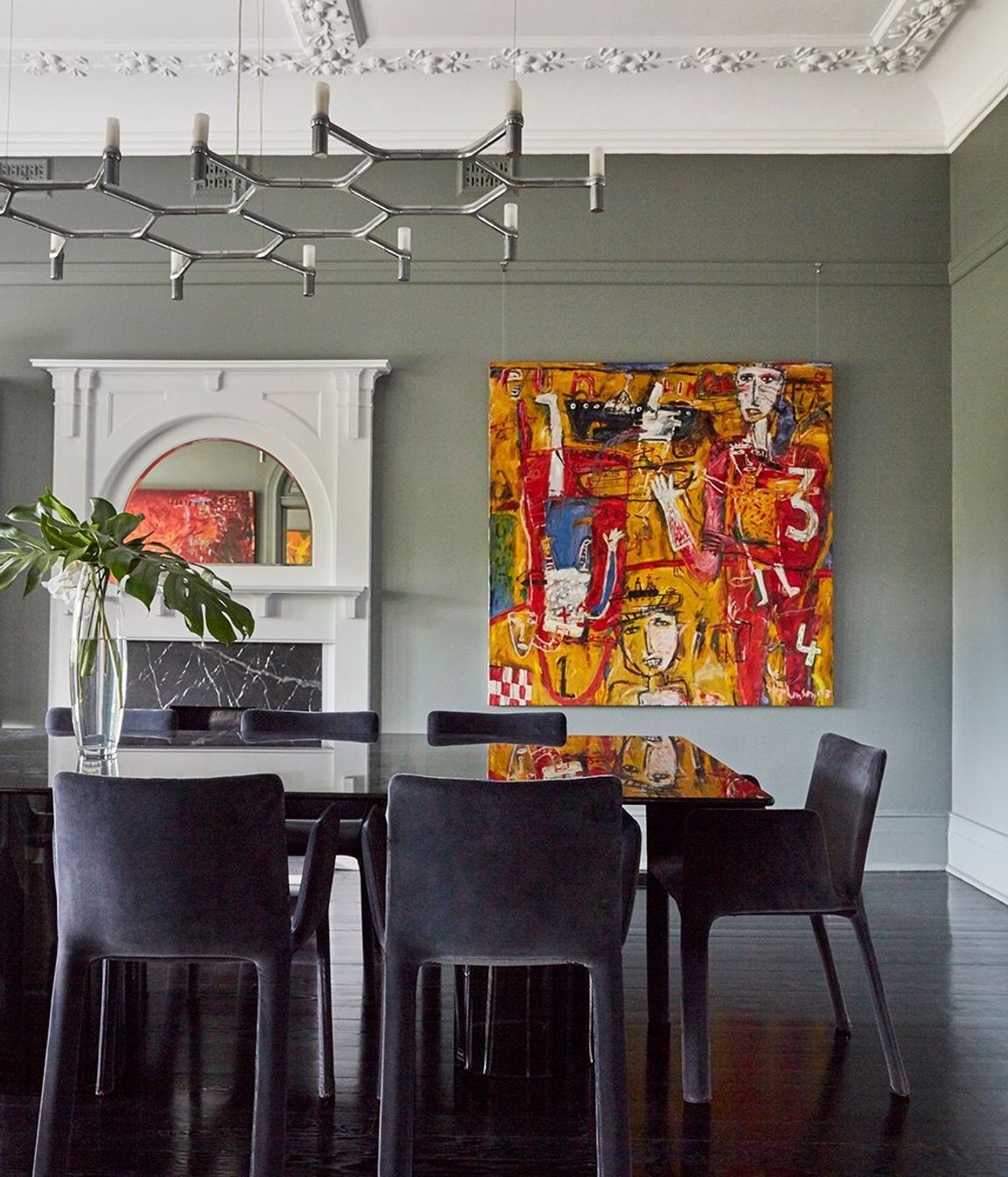 The dining room's dark inky table and chairs integrate with dark, glossy floors.