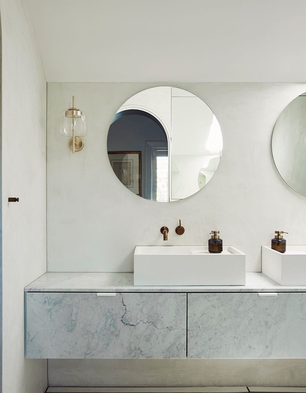 The master ensuite uses curves and a pale palette for a sophisticated and serene bathing space.