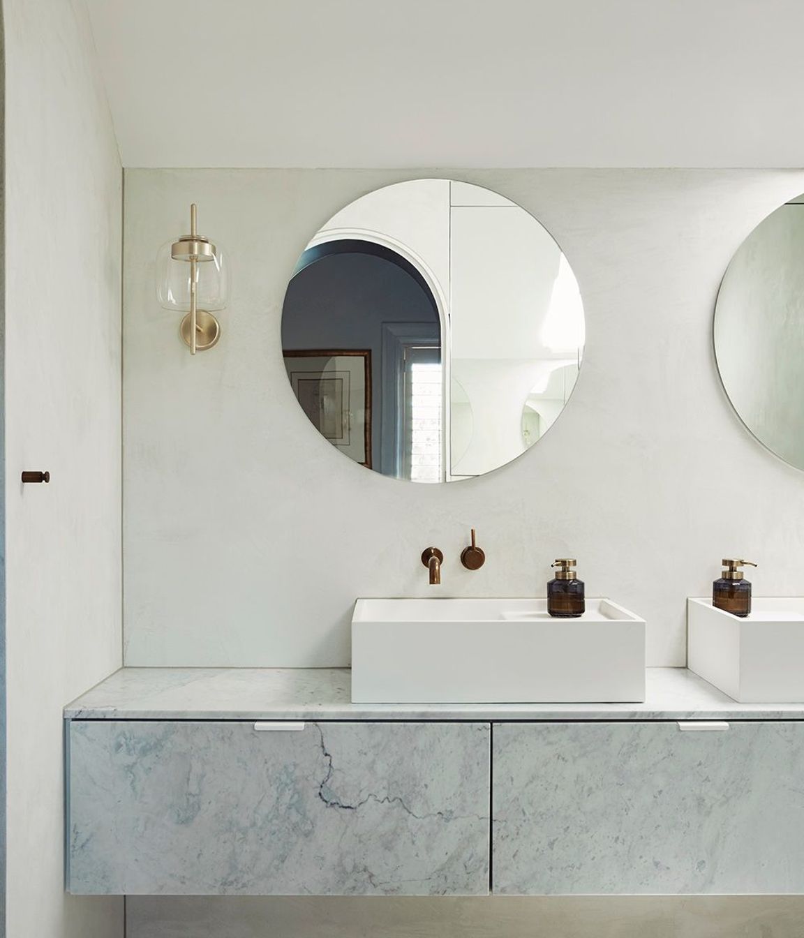 The master ensuite uses curves and a pale palette for a sophisticated and serene bathing space.