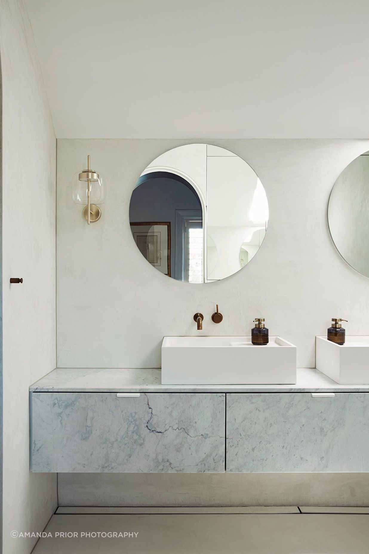 The master ensuite uses curves and a pale palette for a sophisticated and serene bathing space.