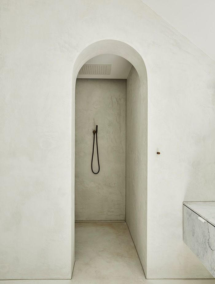 An archway entry adds drama to the master walk-in shower.