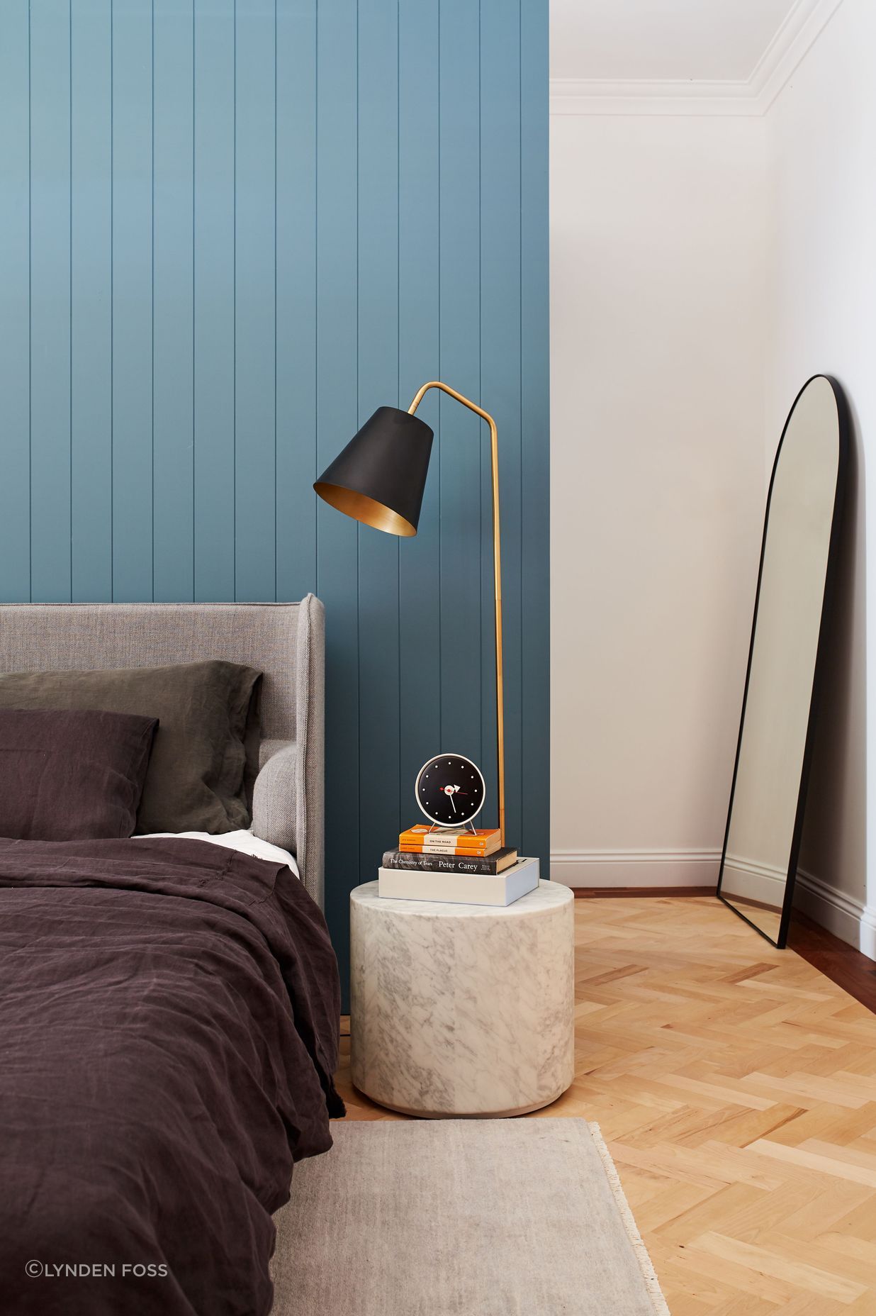 The wall behind the bed divides the room from the walk-in wardrobe behind it.