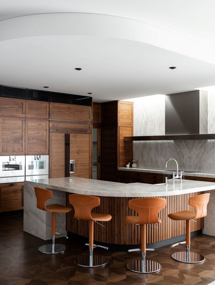 The fluted detail around the kitchen island ties in with the fluted glass internal doors, and the solid walnut cabinetry.