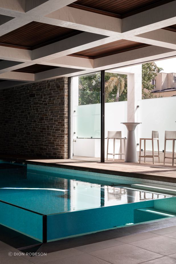 The 63mm glass walls of the pool protrude from the ground, creating the surreal effect of a clear container of water.