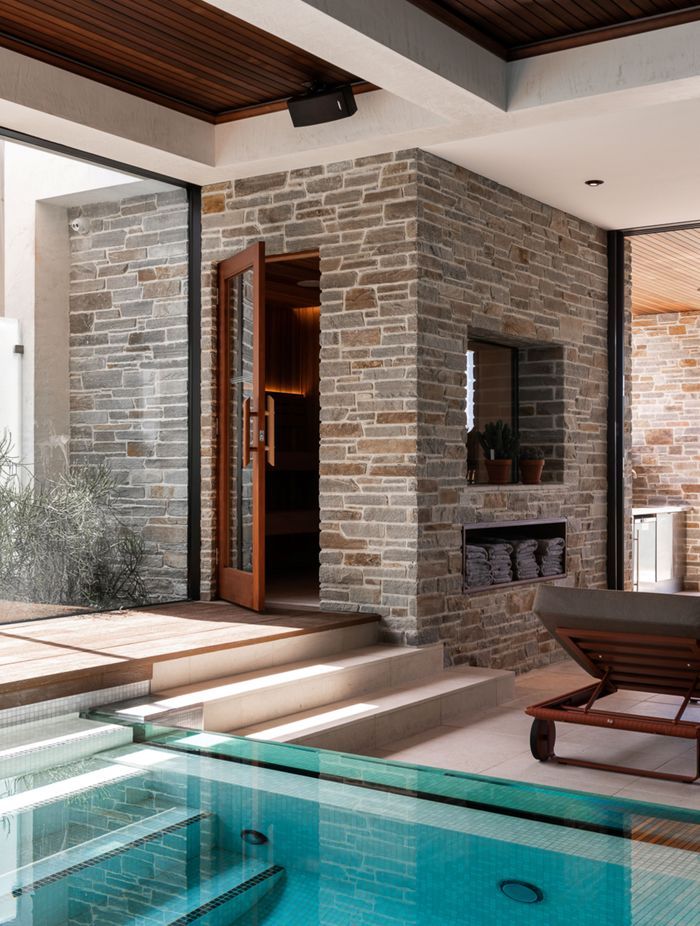 The external stone cladding extends from outdoors to indoors, offering a cohesive textural aesthetic.