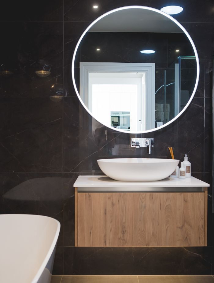 Dark-coloured tiles from Tile Warehouse create a modern aesthetic in the bathrooms.
