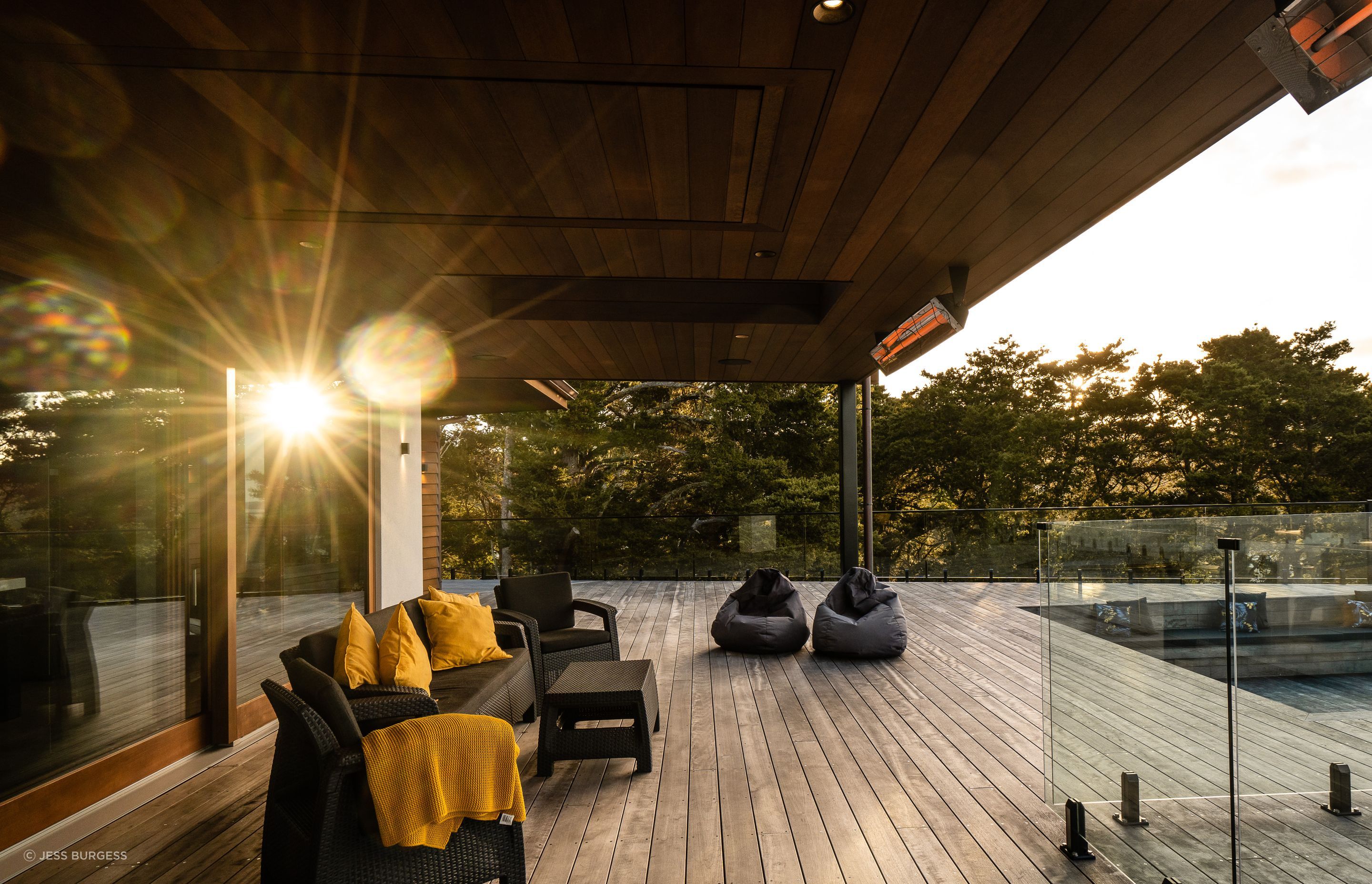 The panel in the eaves contains a retractable TV. The homeowner and an engineer friend made the mechanism using actuators. The deck next to the pool steps down to a conversation pit.