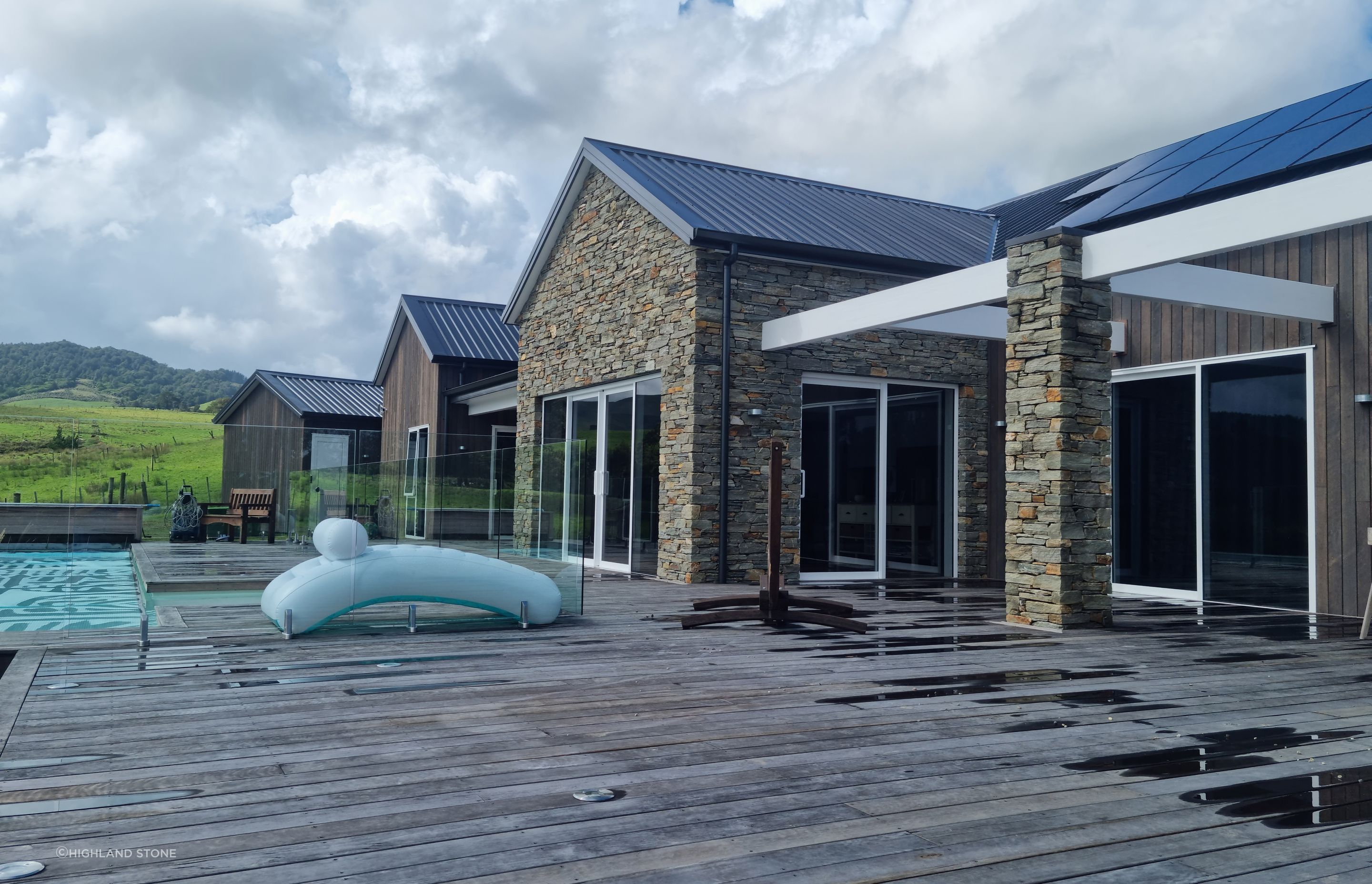 Alternating with dark-stained timber cladding, the stone walls add charm and personality to the sprawling single-story home.