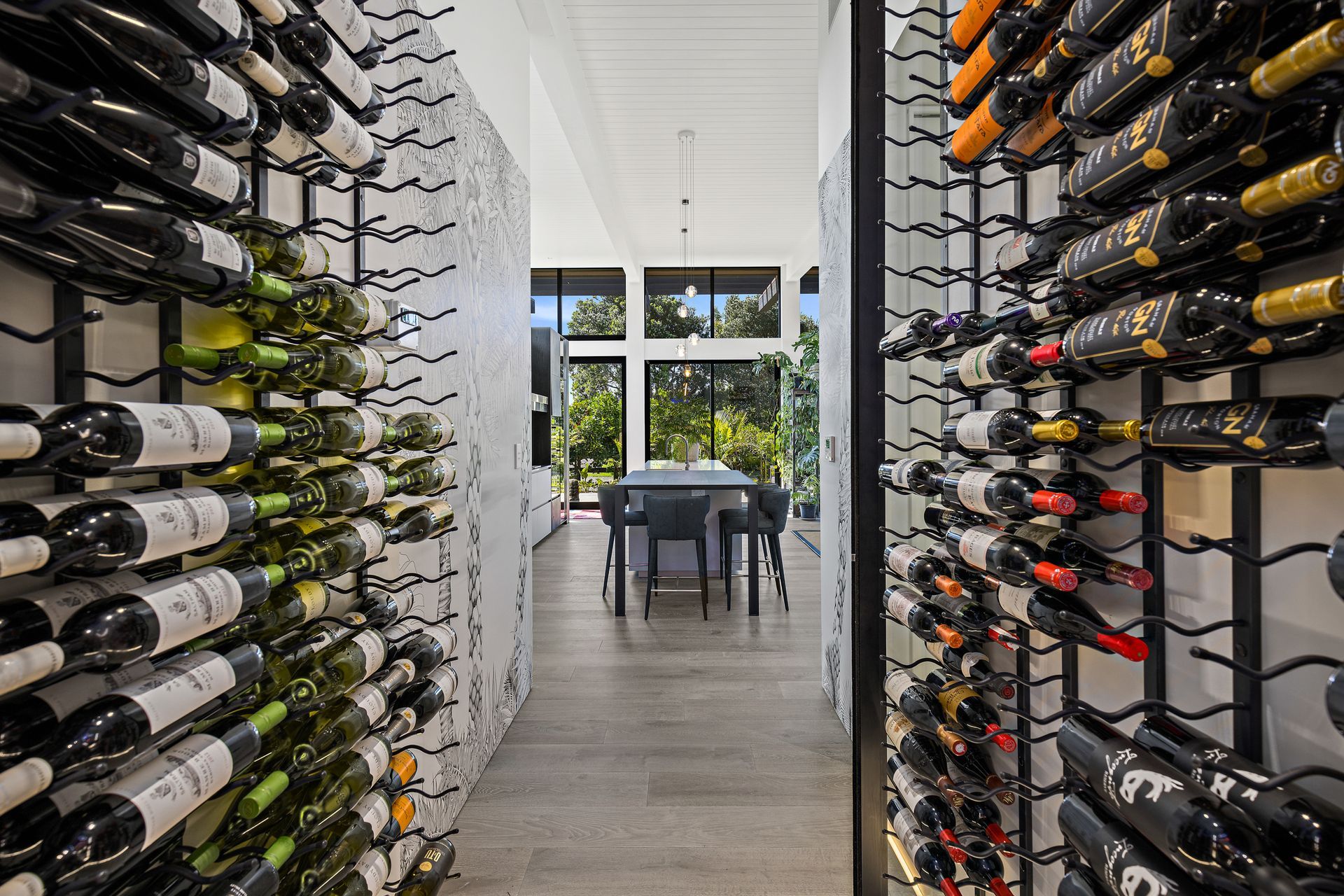 The wine cellar is located close to the kitchen. A palm tree mural at the opening is a nod to the home’s coastal location.