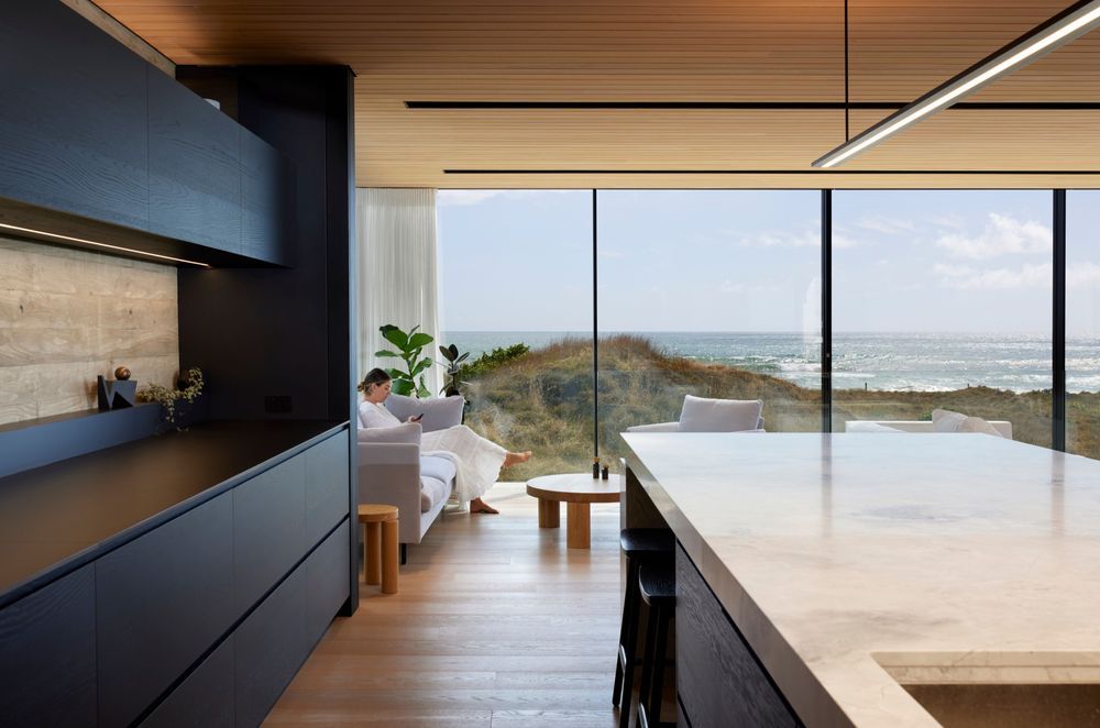 The view from the kitchen through the highly engineered Vitrocsa glazing, with fine transoms and hidden tracks. The kitchen island has a large slab of marble. “It’s like a sculpture.”