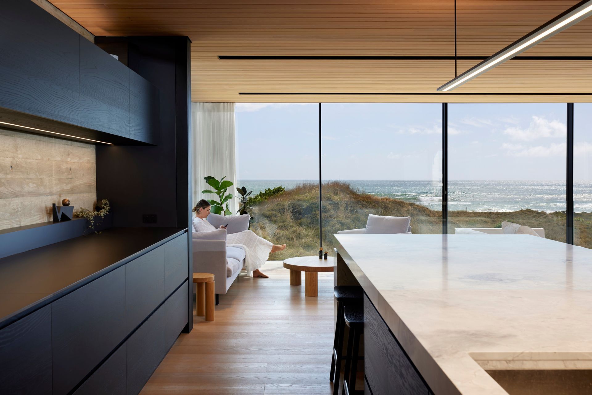 The view from the kitchen through the highly engineered Vitrocsa glazing, with fine transoms and hidden tracks. The kitchen island has a large slab of marble. “It’s like a sculpture.”