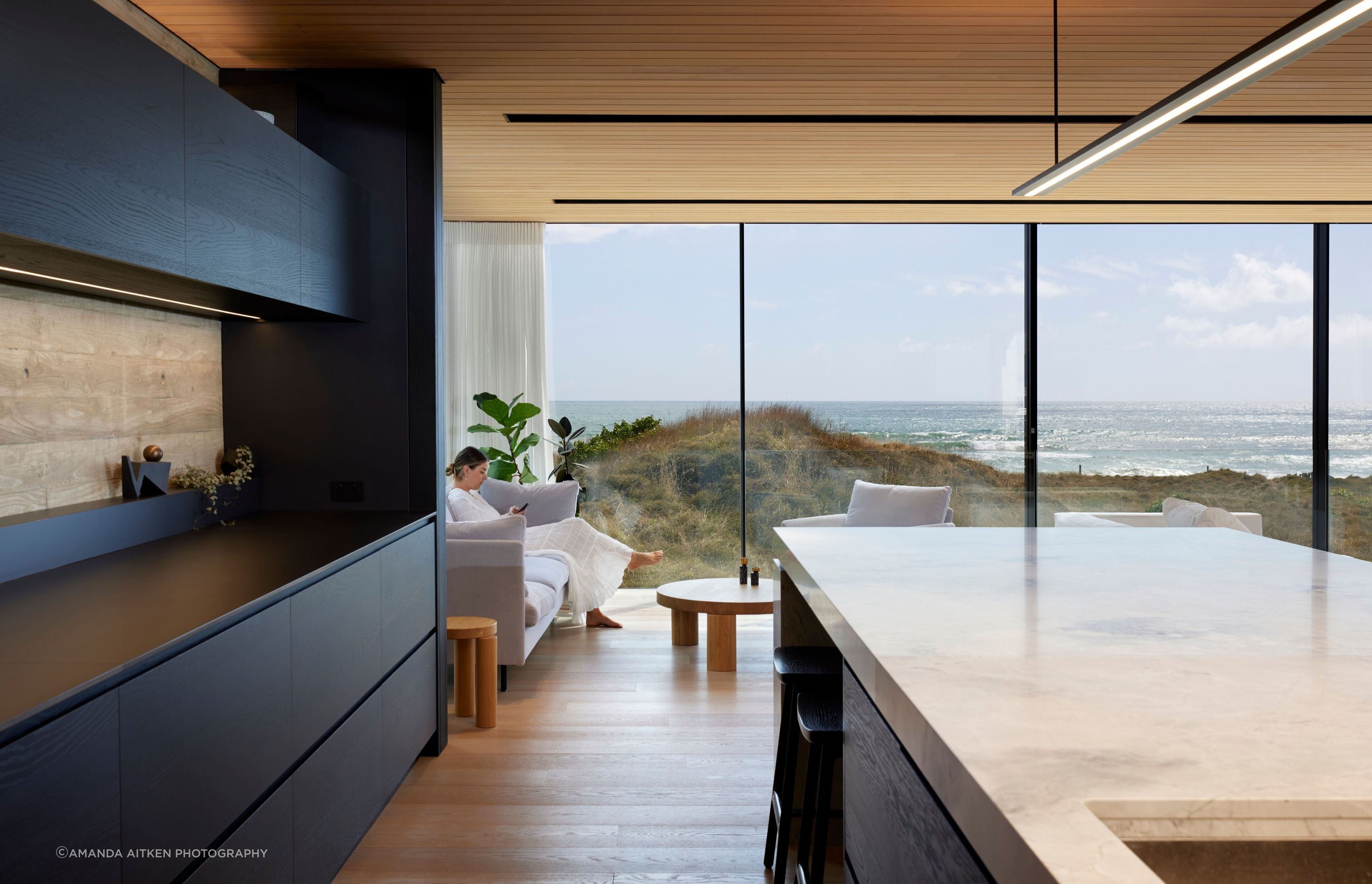 The view from the kitchen through the highly engineered Vitrocsa glazing, with fine transoms and hidden tracks. The kitchen island has a large slab of marble. “It’s like a sculpture.”