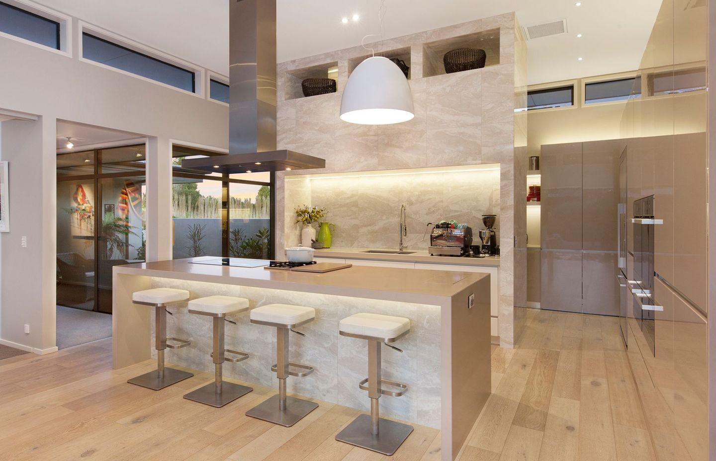 Stone surfaces pair with timber flooring in the kitchen.
