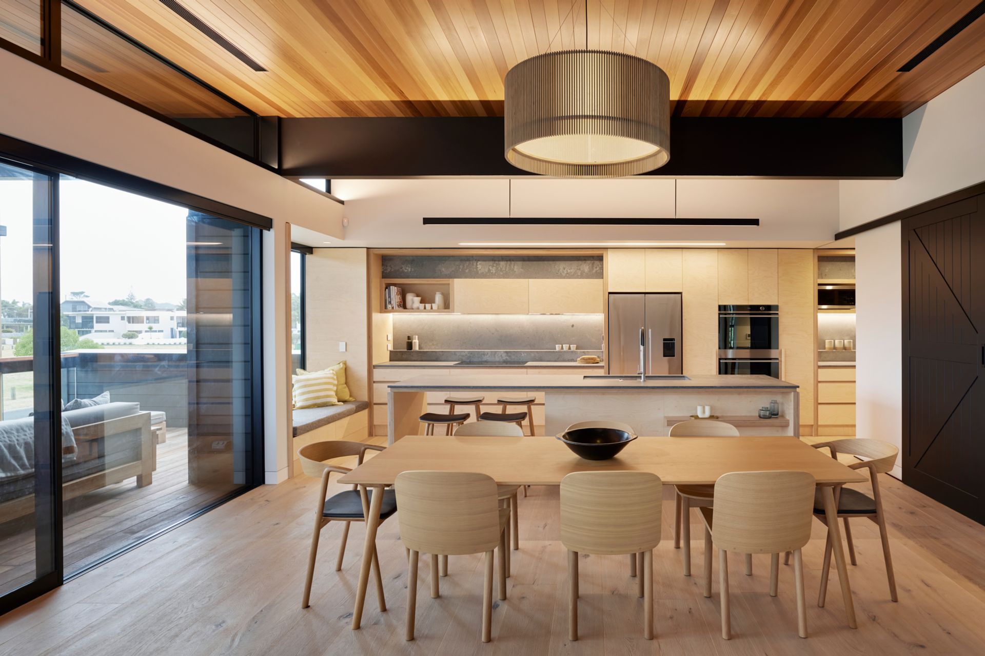 The plywood kitchen finishes and the barn-door style were chosen to keep to a relaxed beachside feel.