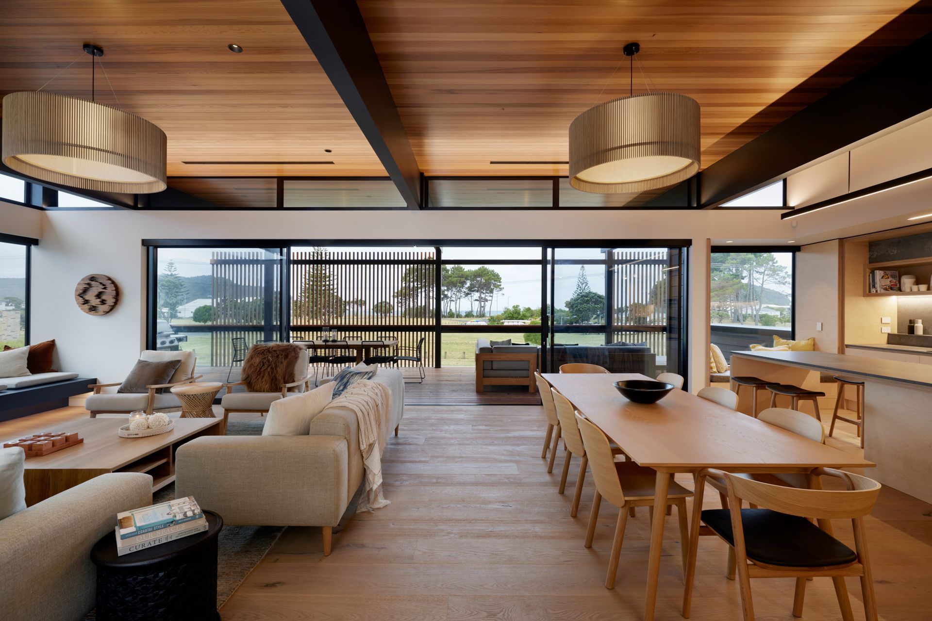 The front deck is carefully screened for a combination of views and privacy. The ceilings are lined in cedar. “We integrate a lot of the lighting,” says Brendon. “We have a lot of bespoke LED lighting which is nice and discreet. Lighting can set different scenes and change the whole feel of a room.” The pendants are iO lights by Maker Design Studio in Tauranga.