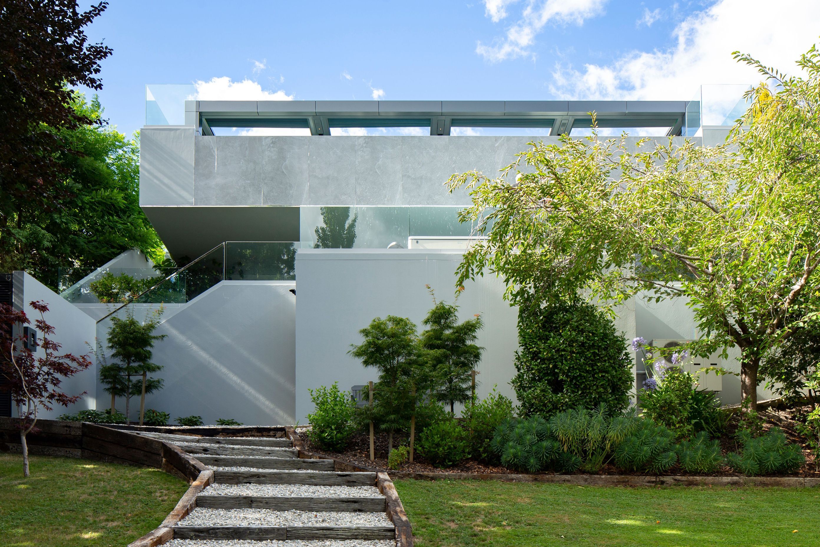 The lowest level is met by the deep greens of an established, landscaped garden and the rich blues of Lake Wakatipu. 