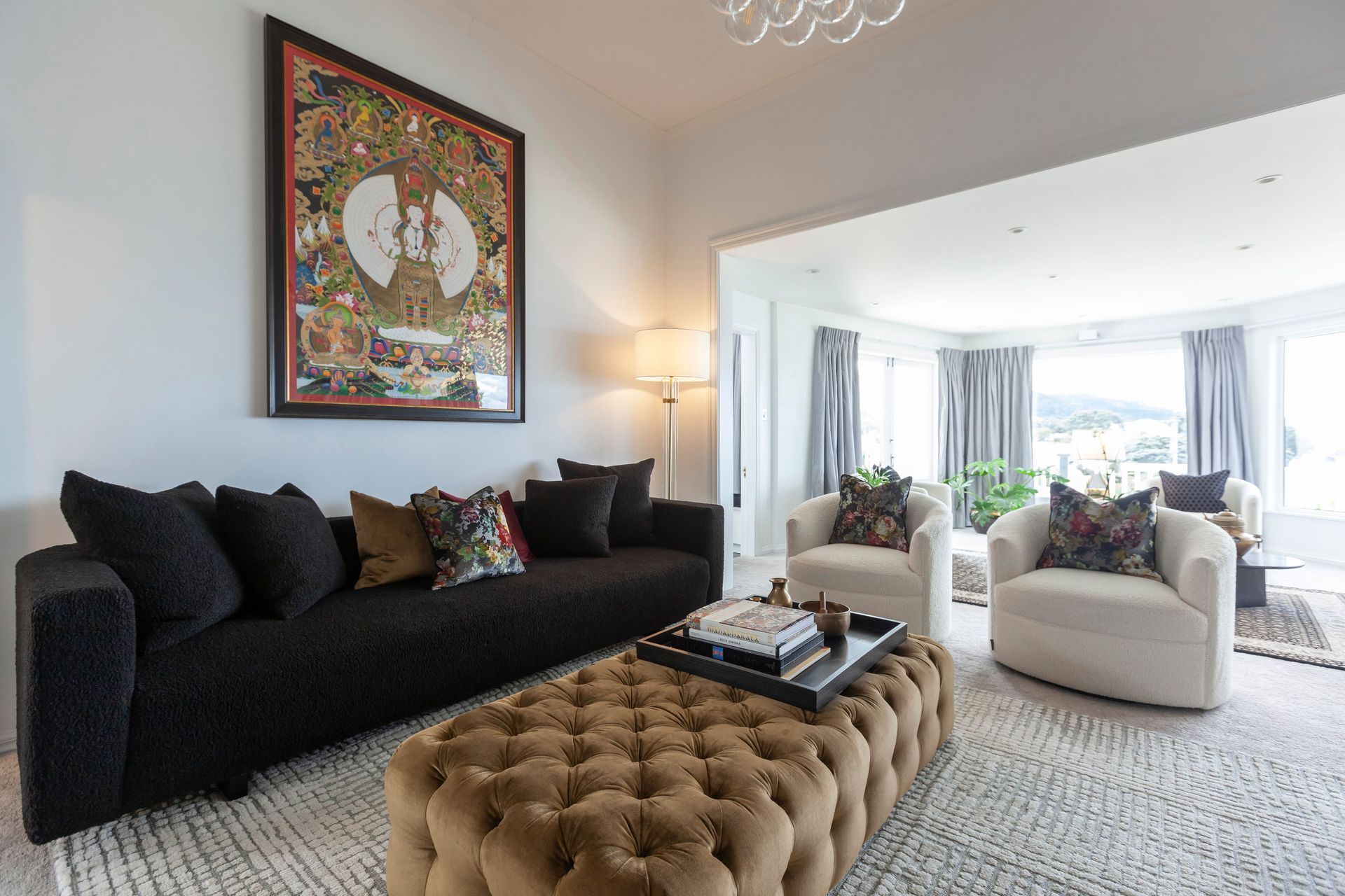 “The gold velvet of the ottoman also enhances the brass and gold elements around the living space and ties in with the gold in the Buddha print.”
