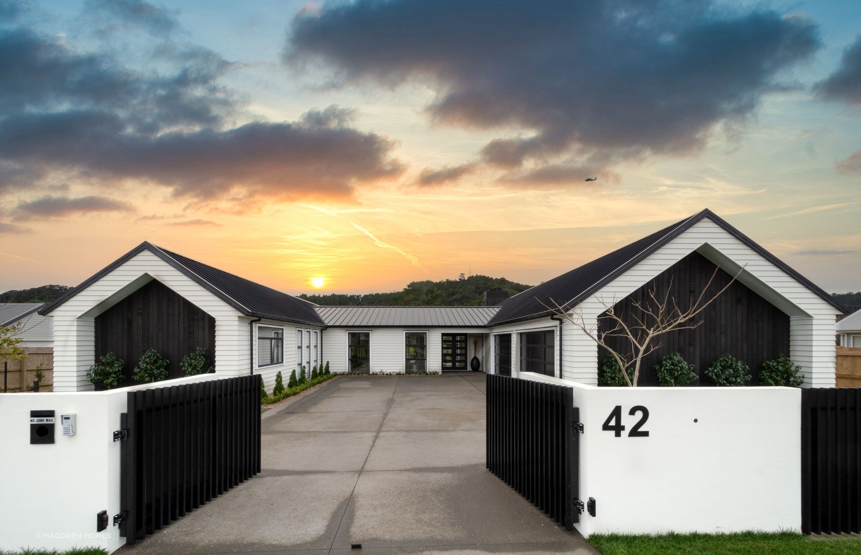 The bold double contrast between black and white combined with vertical and horizontal weatherboards makes an immediate impact at 42 Fruitland Road in Huapai. | Photography: Danilo Dijamco