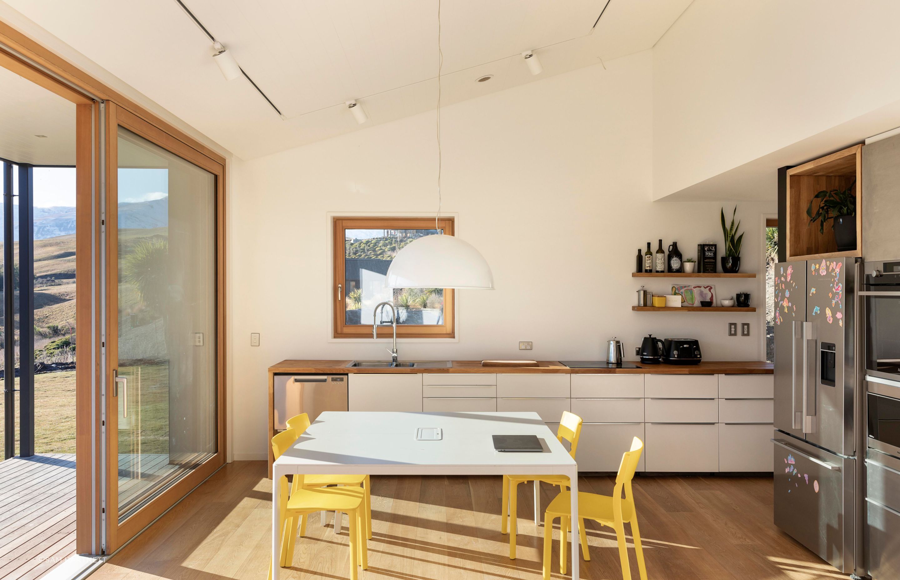 The living, kitchen, and dining area extends onto a deck.