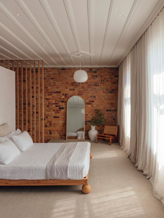In the bedroom, the original kauri ceiling and brickwork have been restored.
