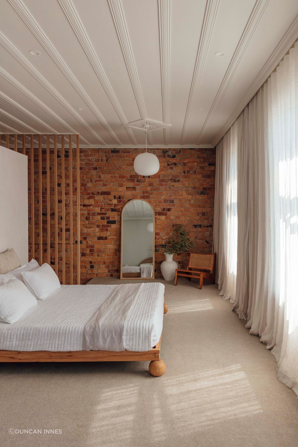 In the bedroom, the original kauri ceiling and brickwork have been restored.