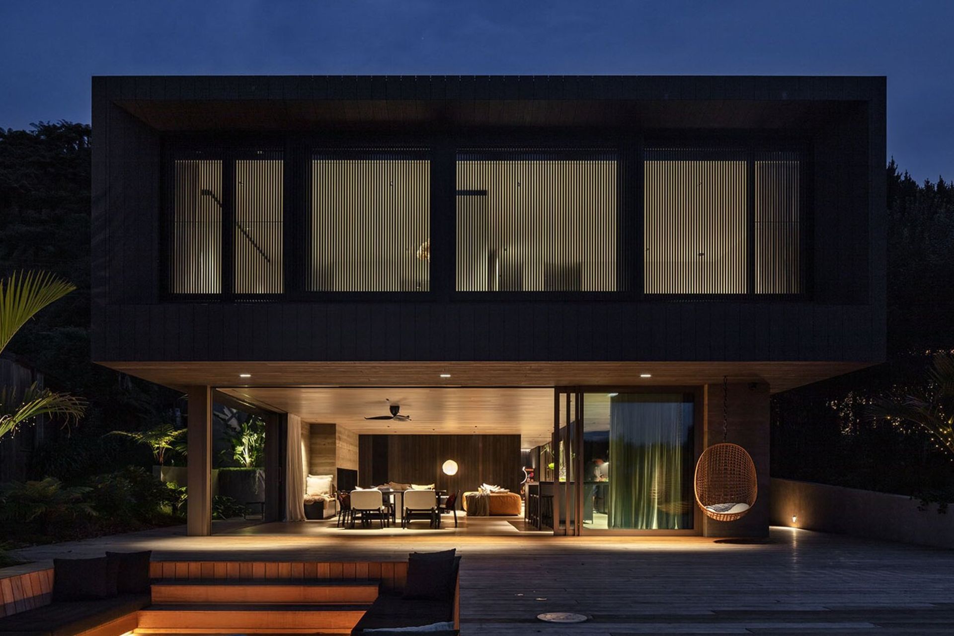 Sam and Fiona Fillmore’s lakehouse on the edge of Lake Rotoiti was designed by Evelyn McNamara of Evelyn McNamara Architecture. The ground-level glass doors open completely to welcome and provide a connection to Sam’s childhood bach next door.