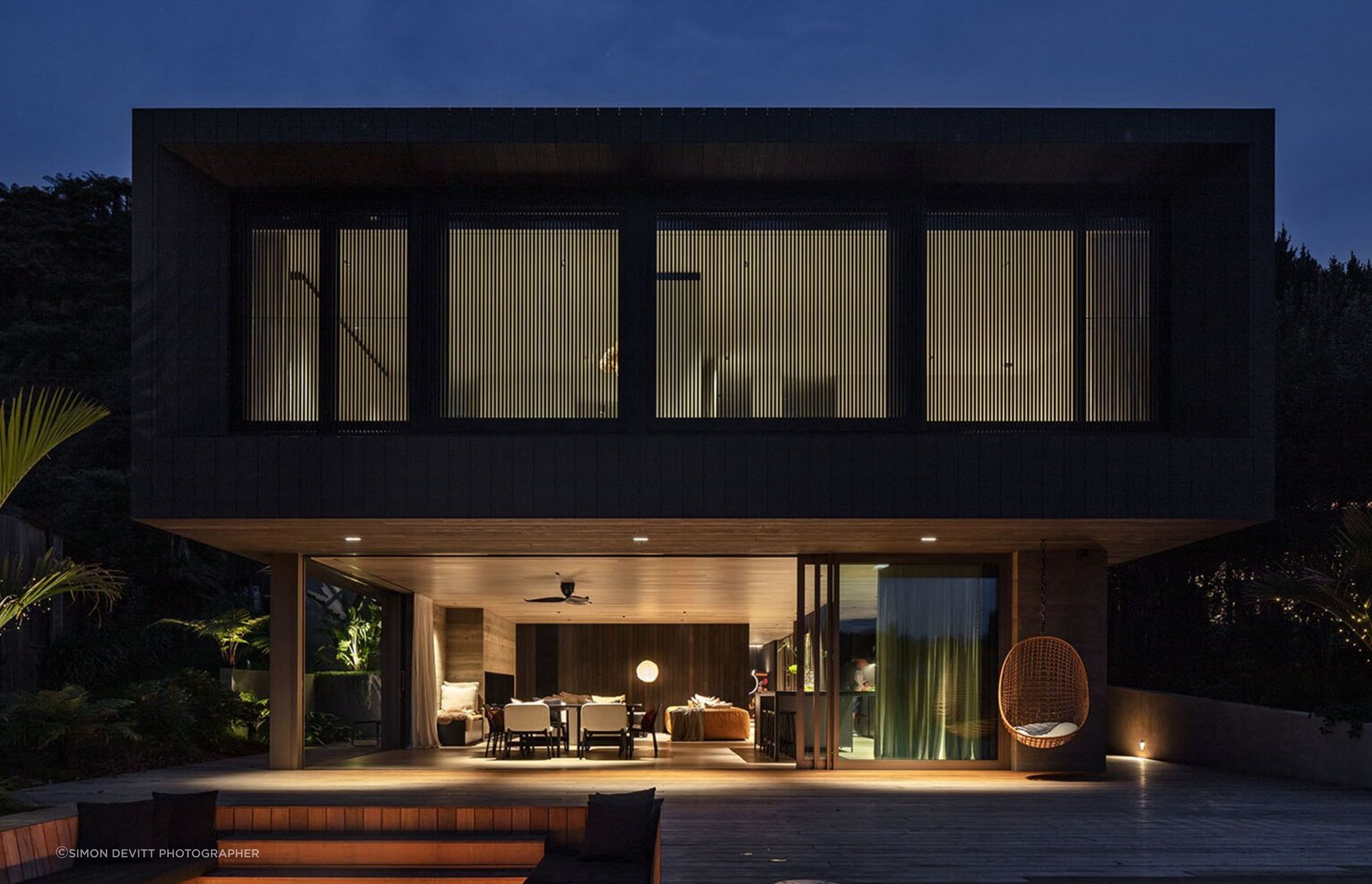 Sam and Fiona Fillmore’s lakehouse on the edge of Lake Rotoiti was designed by Evelyn McNamara of Evelyn McNamara Architecture. The ground-level glass doors open completely to welcome and provide a connection to Sam’s childhood bach next door.