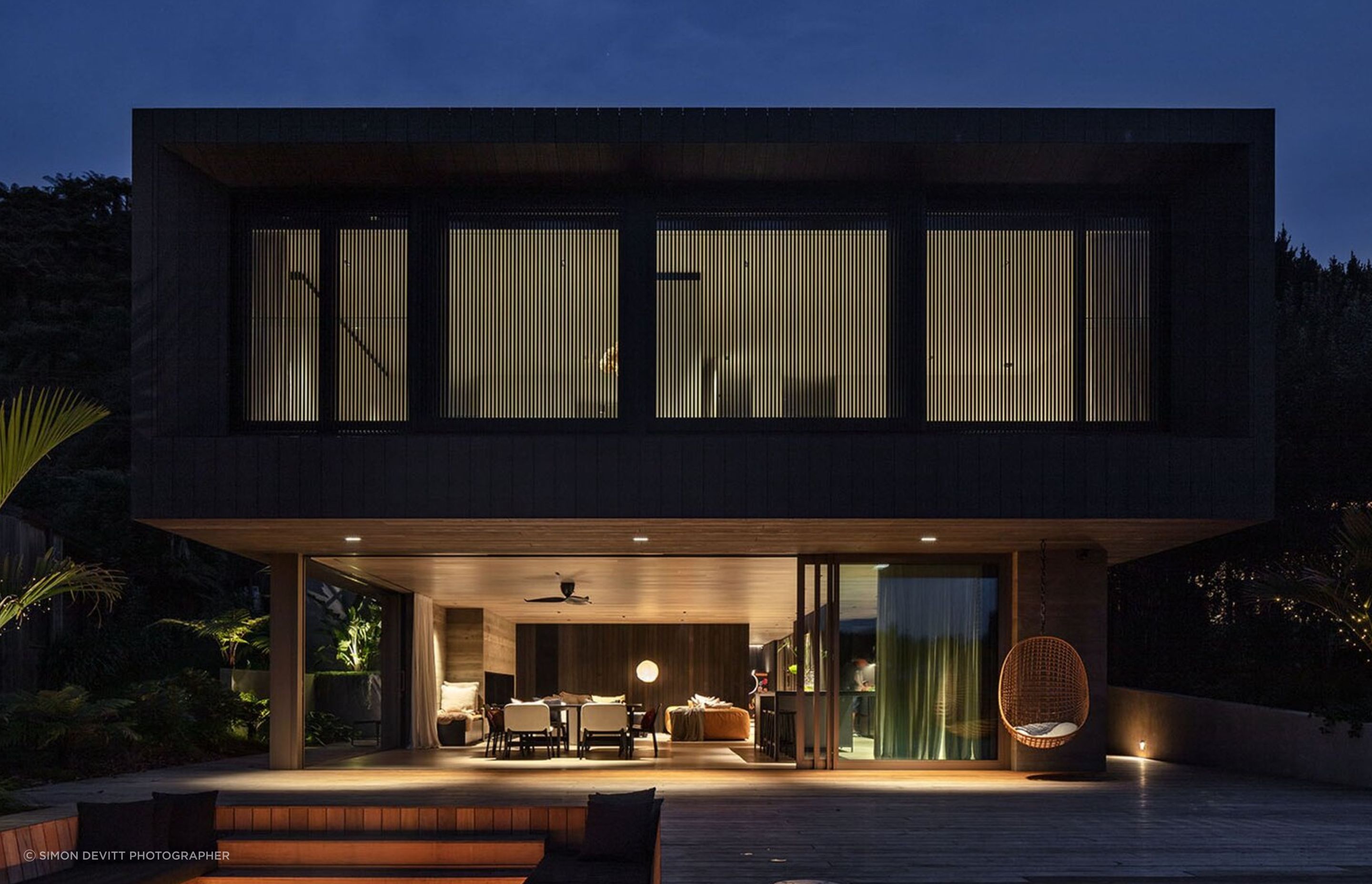 Sam and Fiona Fillmore’s lakehouse on the edge of Lake Rotoiti was designed by Evelyn McNamara of Evelyn McNamara Architecture. The ground-level glass doors open completely to welcome and provide a connection to Sam’s childhood bach next door.