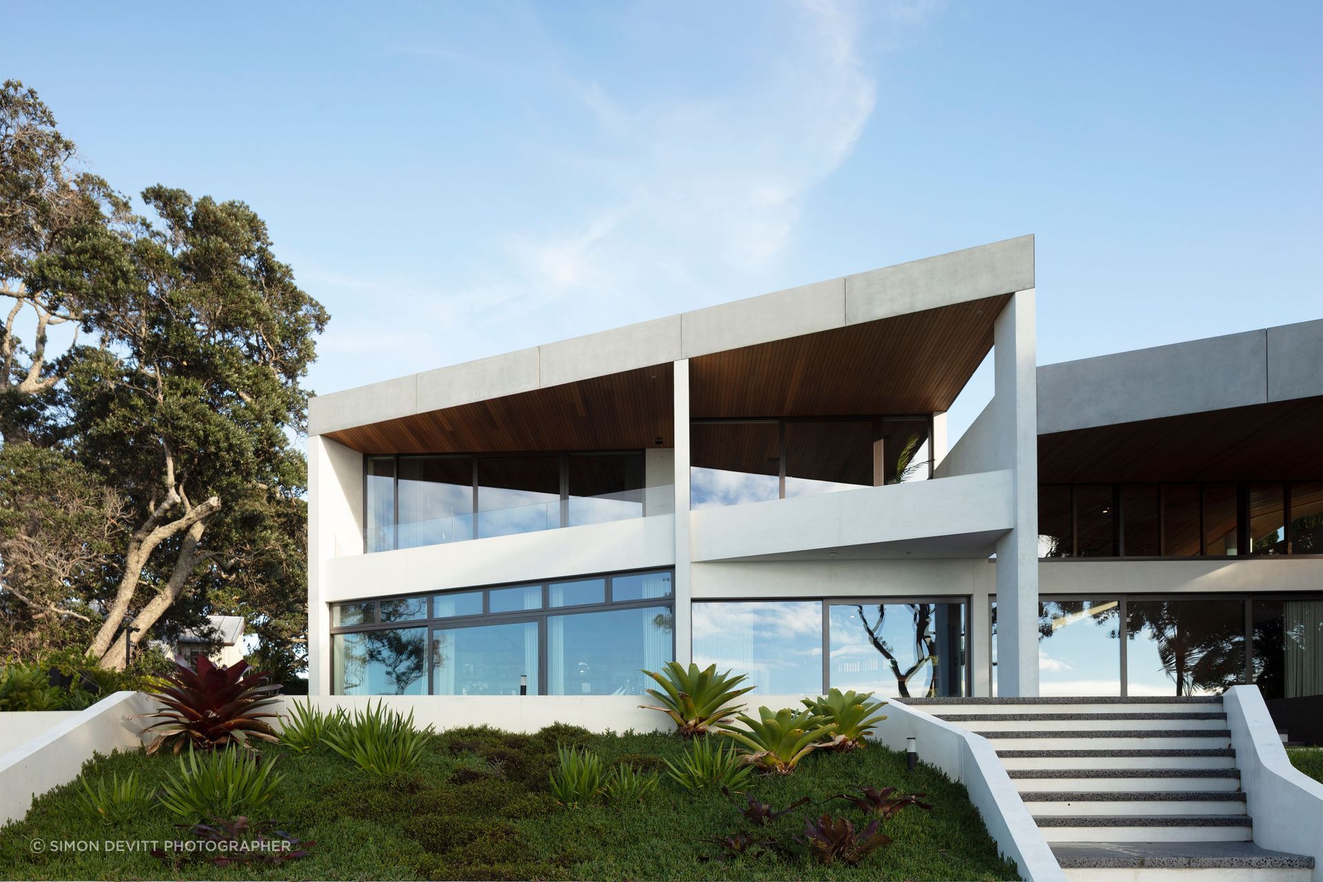 Perched on the clifftops overlooking Auckland’s Waitemata Harbou, the concrete gives the house a wonderful sense of mass and solidity.