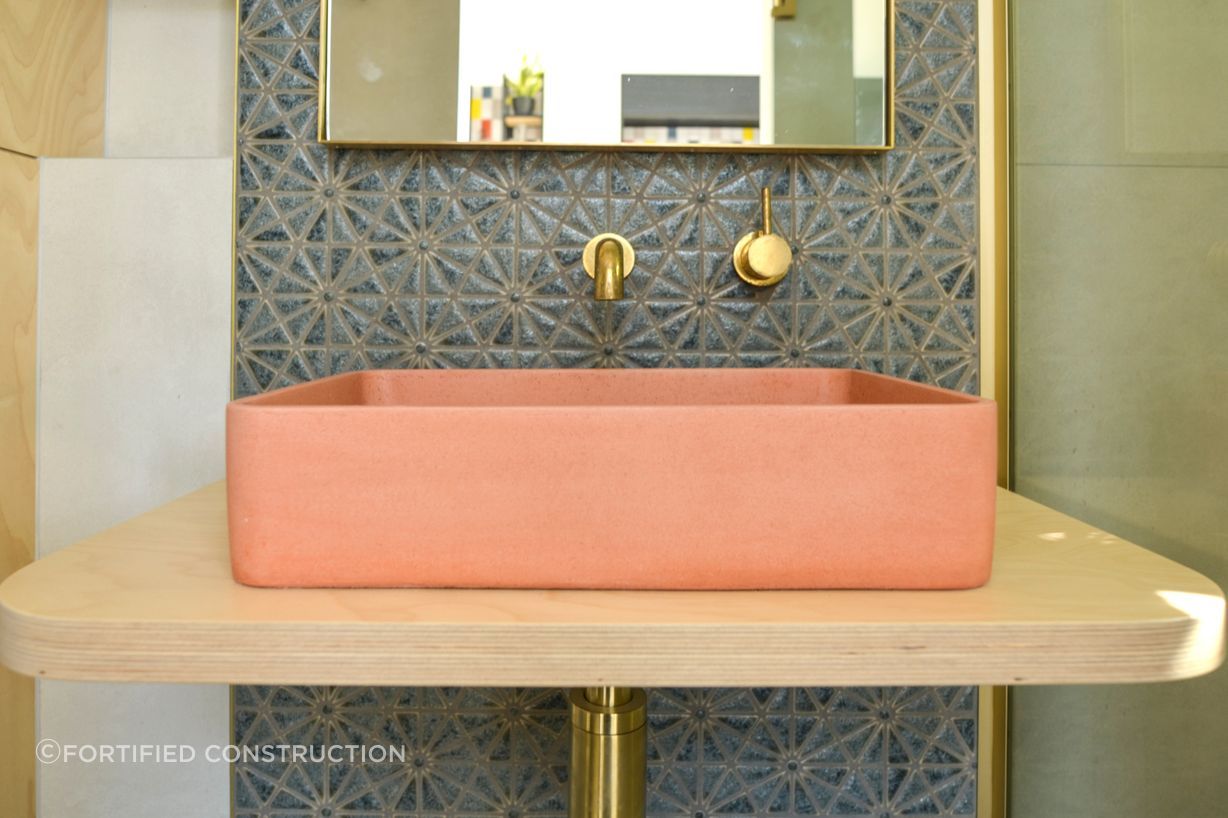 The salmon pink vessel sink showcases the client's affinity for colour.