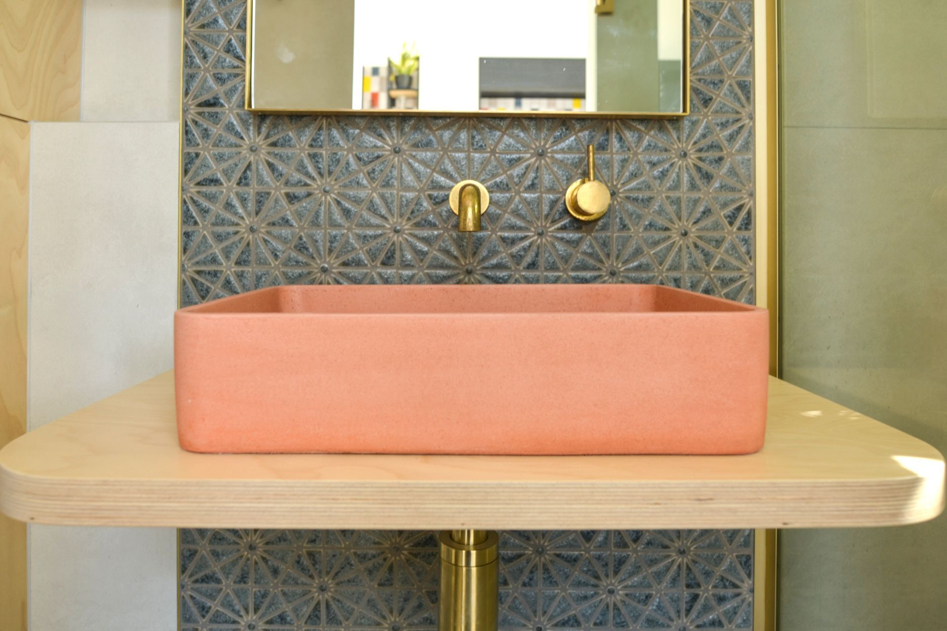 The salmon pink vessel sink showcases the client's affinity for colour.