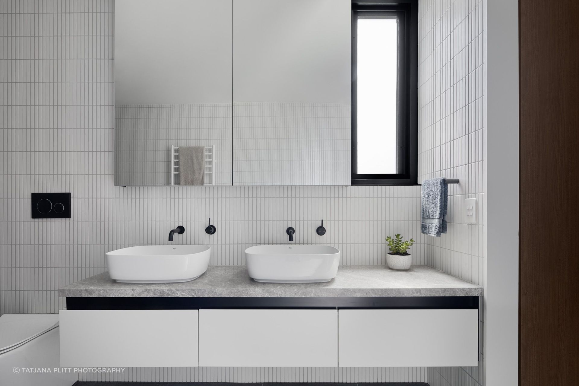 Similar to downstairs,  the bathroom has a monochromatic scheme of black and white.