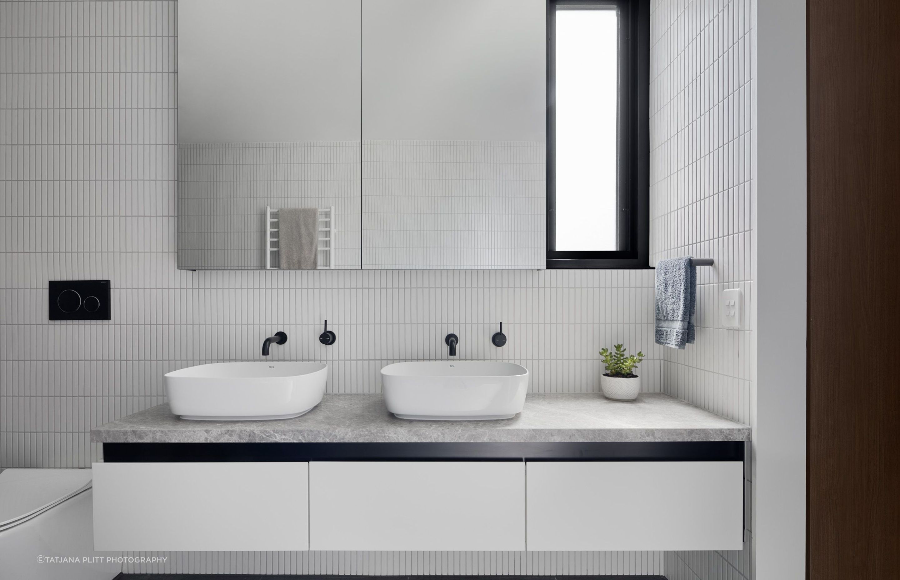 Similar to downstairs, the bathroom has a monochromatic scheme of black and white.