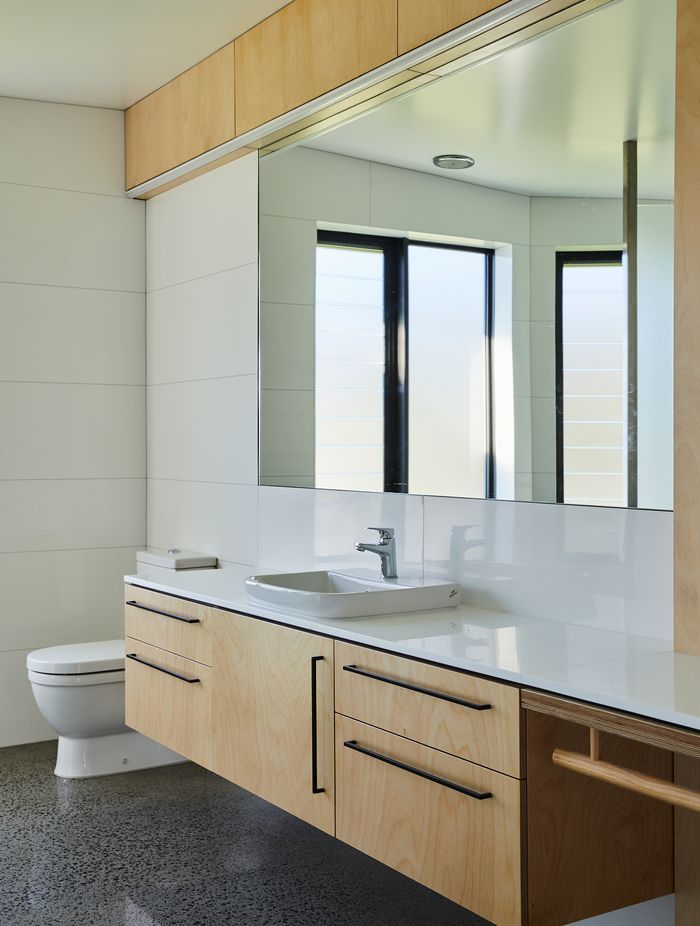 The white Marazzi Essenziale Lux tiles are from The Tile People. Birch ply cabinetry carries through from the rest of the house and the black U Handles are by Katalog.