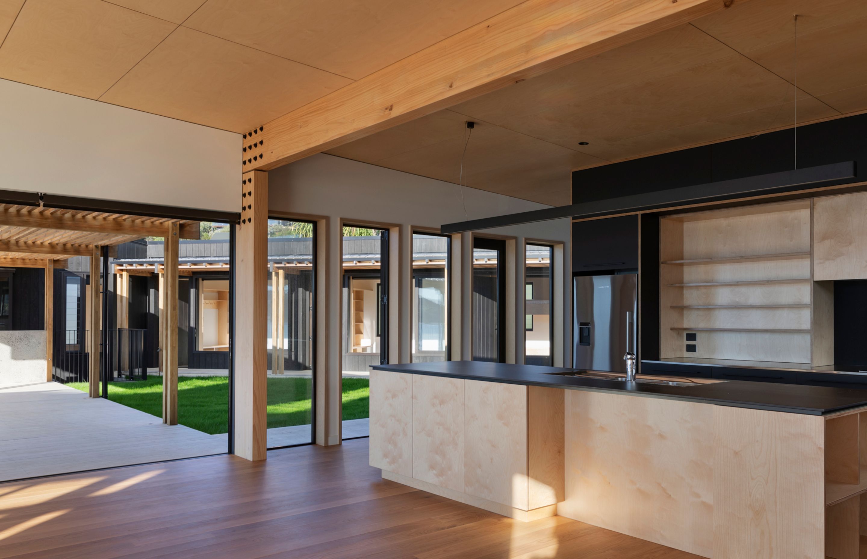 The ceilings and kitchen cabinets are birch ply by Plytech. The benchtops are Neolith porcelain from SCE Stone & Design.