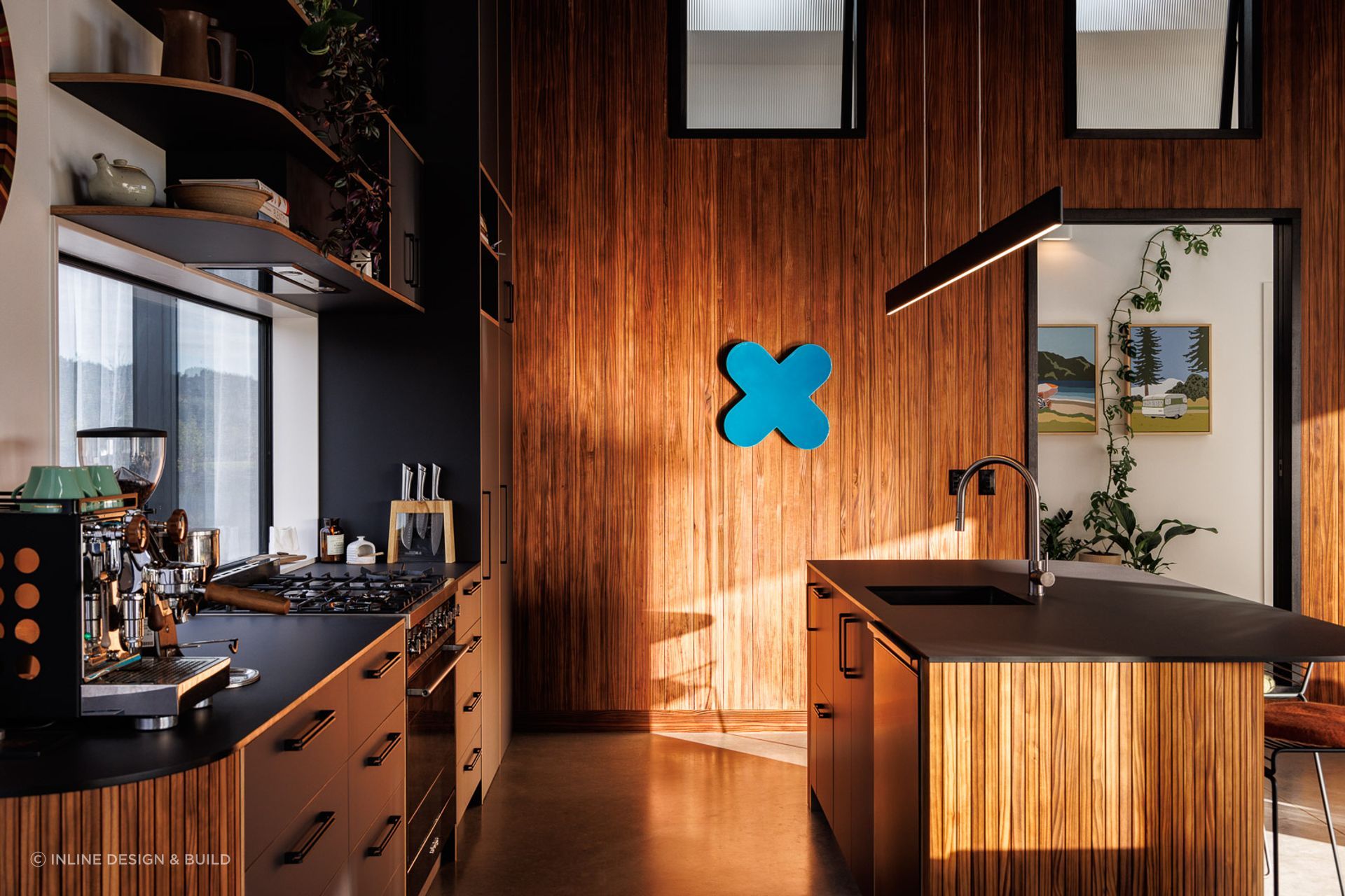 The material palette is organic and warm, using thermally modified timber in interior and exterior spaces to deepen the connection between the two.