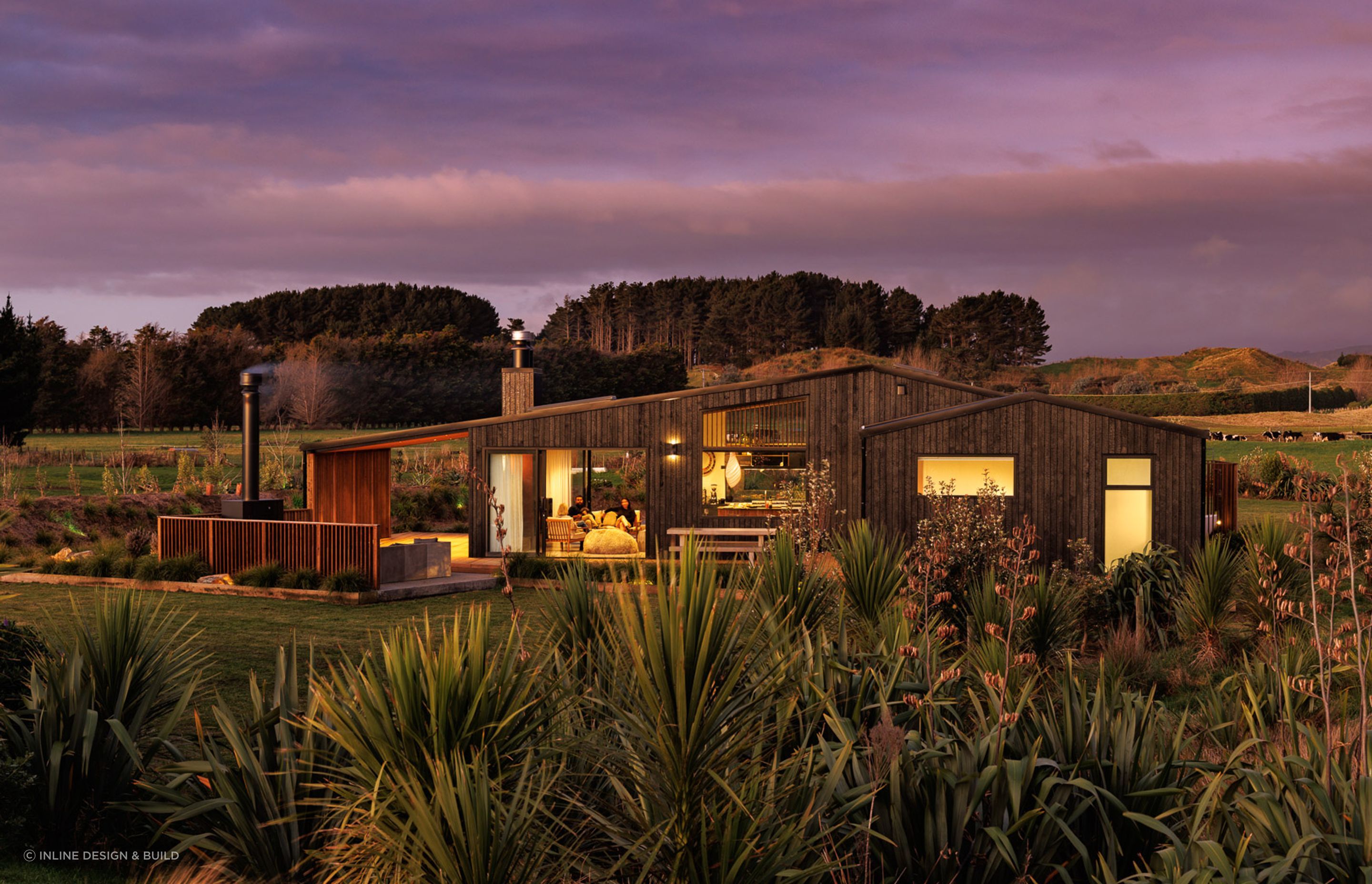 The site is surrounded by verdant fields and framed by the silhouettes of mountains.