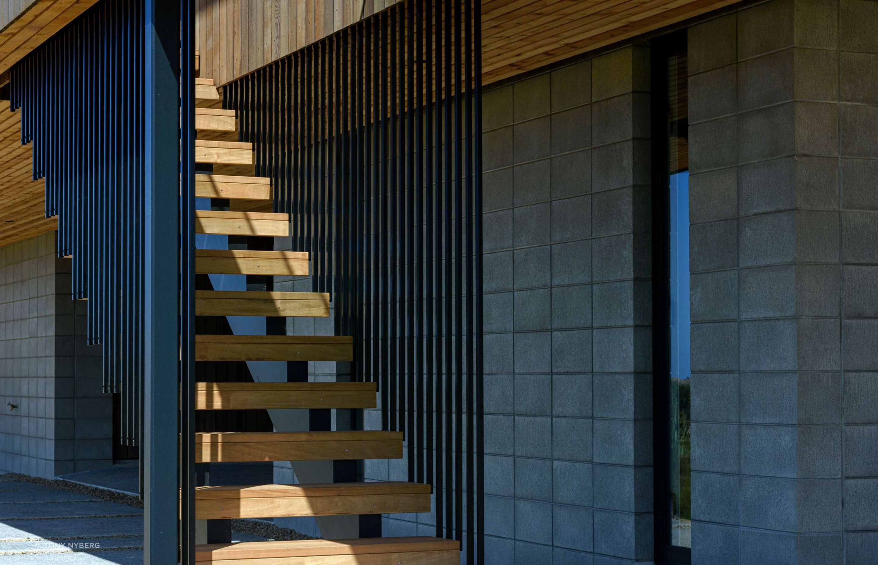 A block base combines with black aluminium and cedar for the home's exterior.