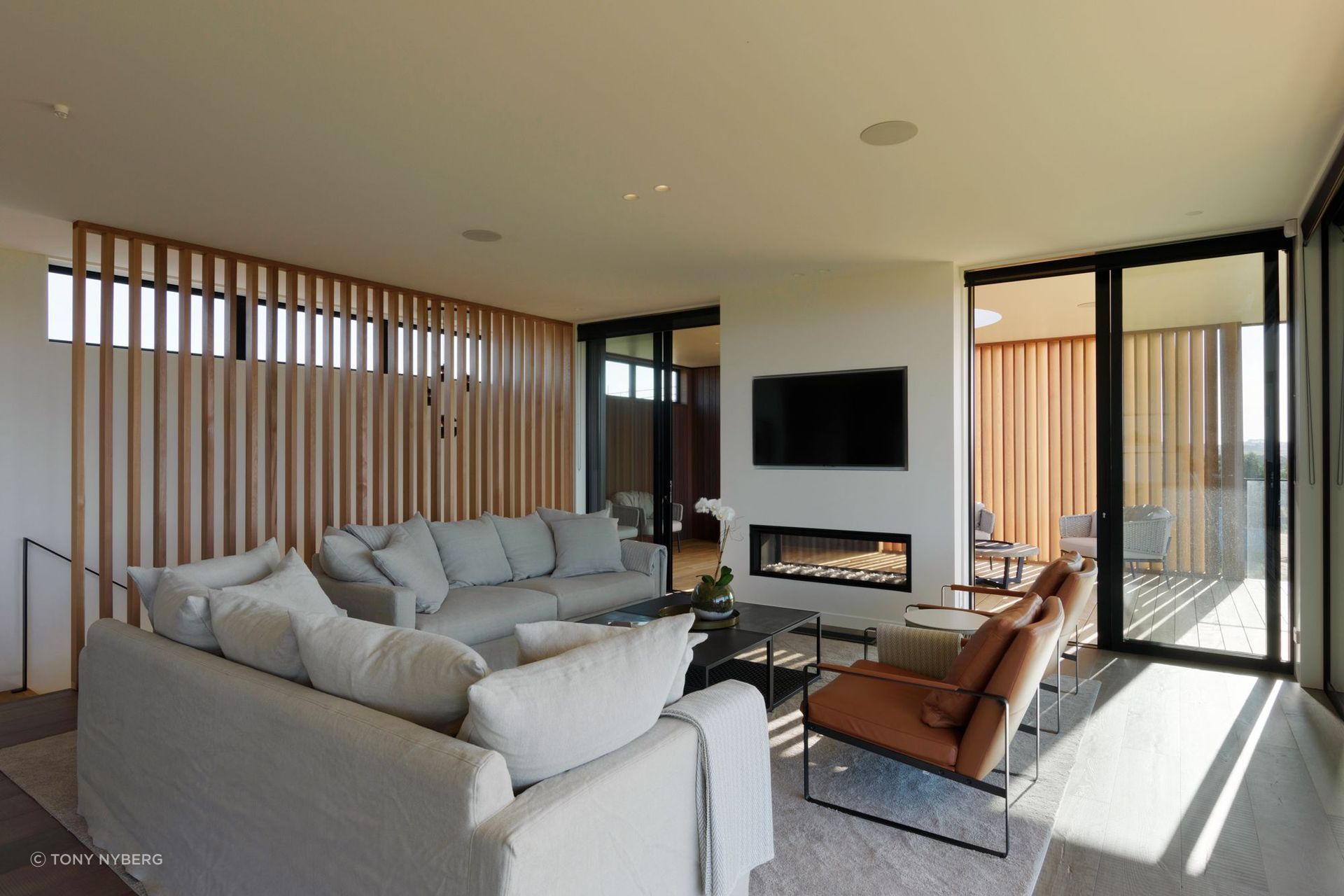 A double-sided fireplace sits at the junction between the indoor and outdoor living areas.