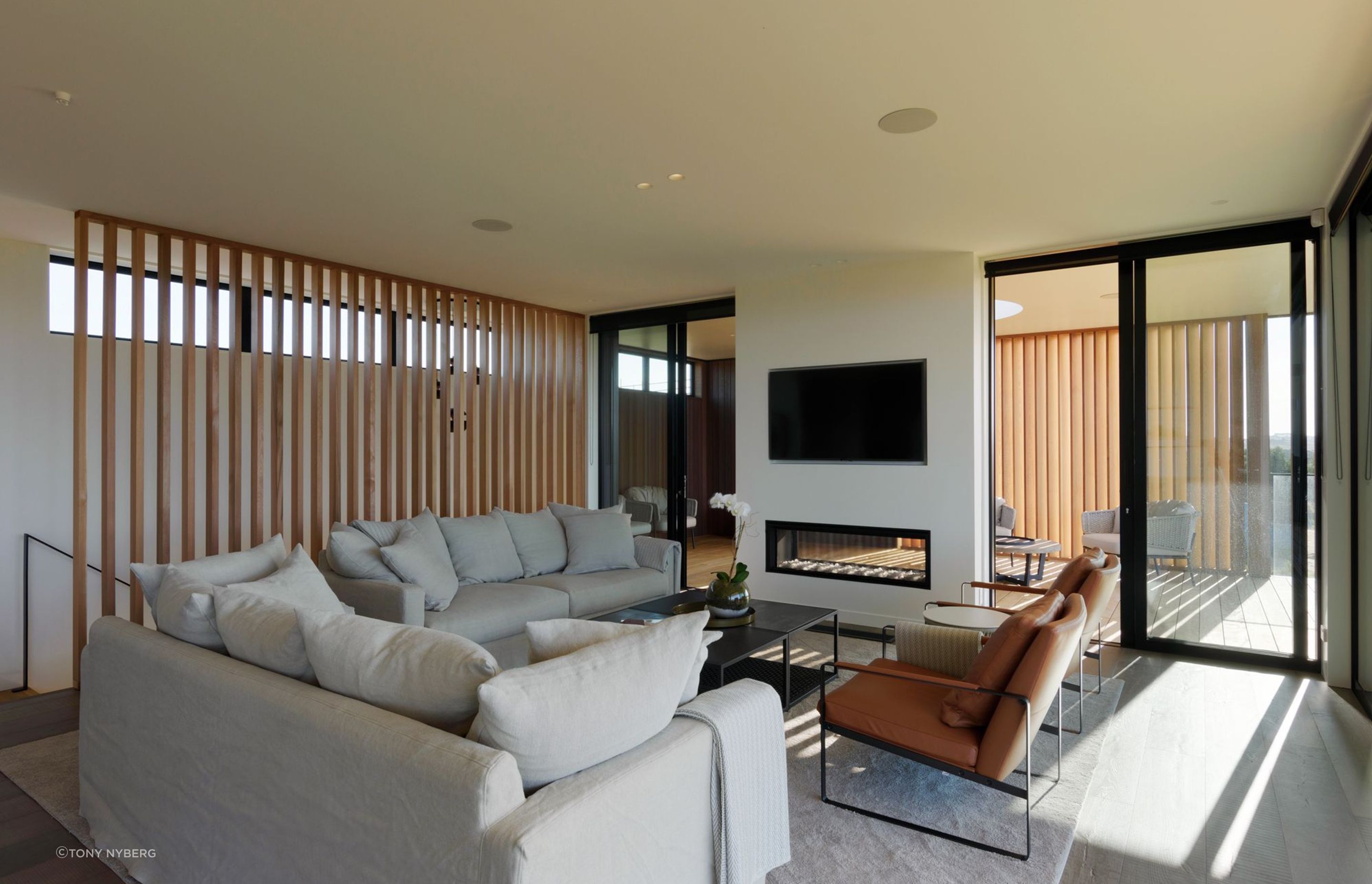 A double-sided fireplace sits at the junction between the indoor and outdoor living areas.