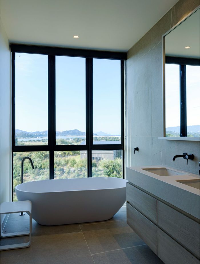 A freestanding bath adjacent to floor-to-ceiling windows makes the most of the expansive views.