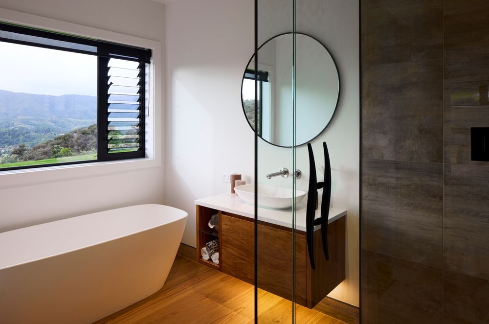 The guest bathroom is equally elegant with natural timbers and a freestanding bathtub.