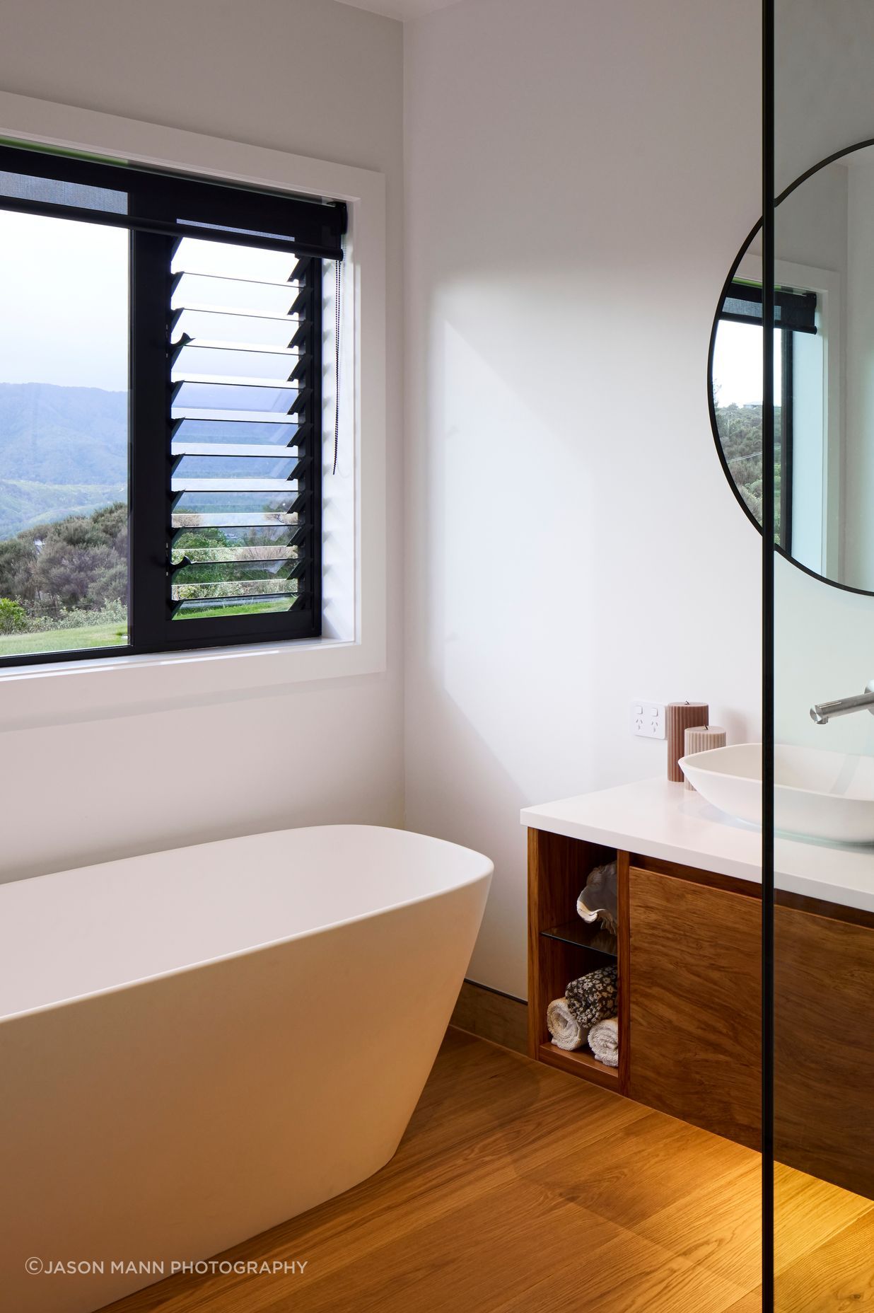 The guest bathroom is equally elegant with natural timbers and a freestanding bathtub.