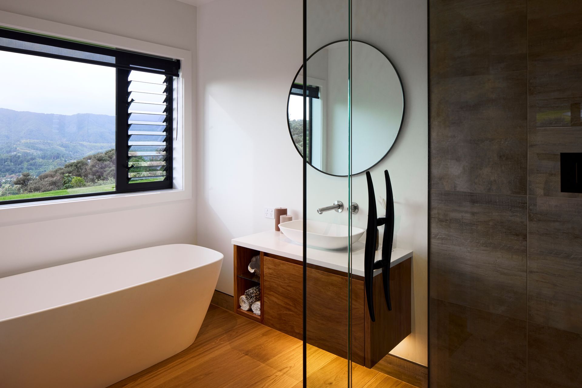 The guest bathroom is equally elegant with natural timbers and a freestanding bathtub.