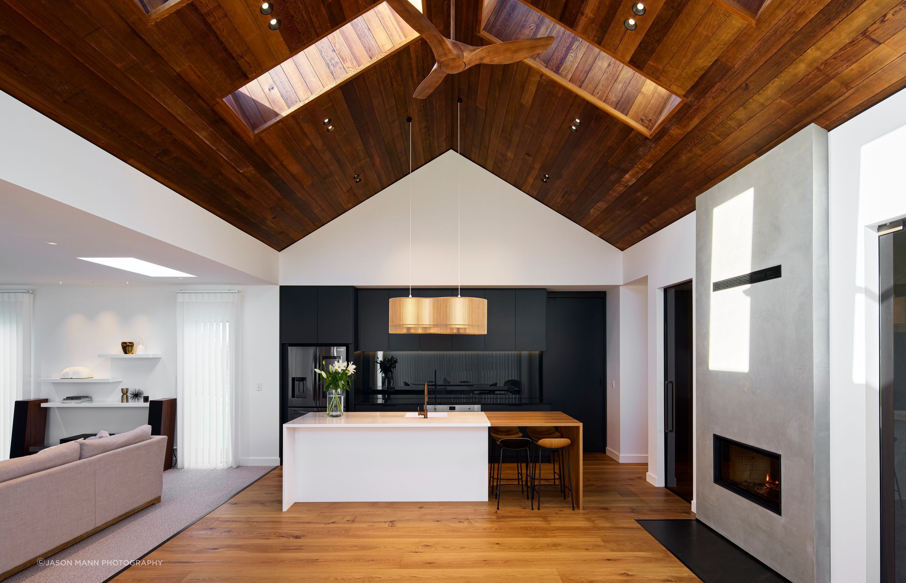 Cedar lines the ceiling, with hardwood American oak flooring a contrast to the sleek, dark kitchen cabinetry.