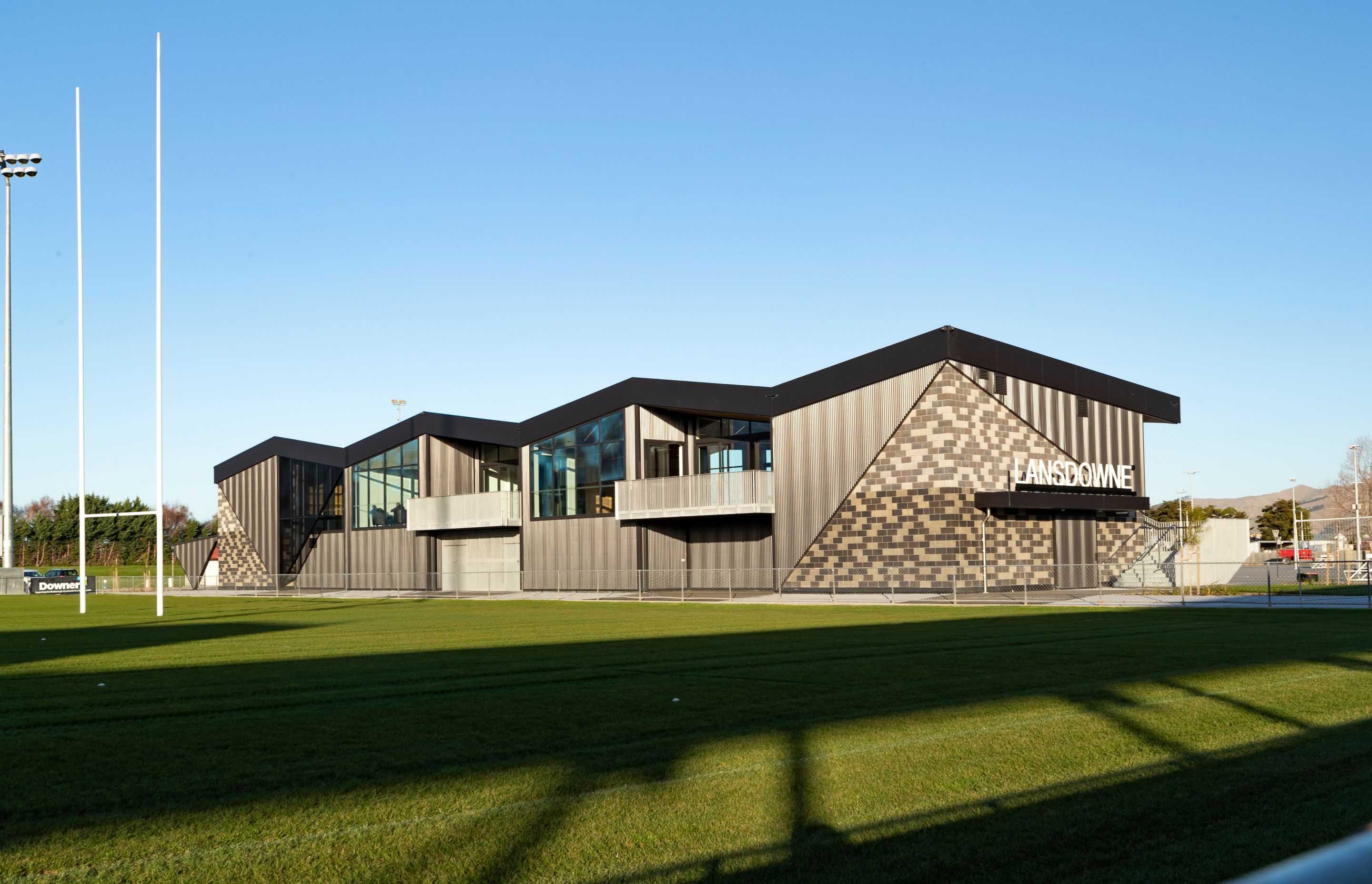 The combination of block walls juxtaposed against a light-weight corrugate structure, with a folded roof floating above gives the building a textural and geometric interest.