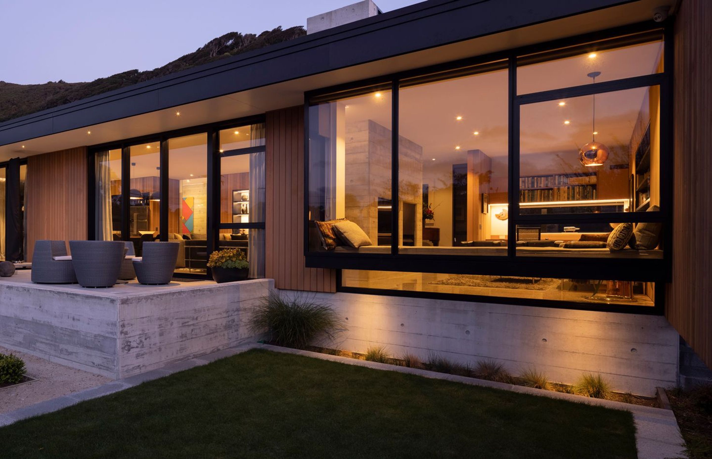 A floating wing wall on the right screens the terrace from southerly winds and provides a sense of enclosure. The cosy window seat in the den area looks over the garden.